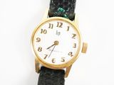 une montre-bracelet en or avec un bracelet en cuir noir
