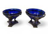 a pair of blue glass bowls sitting on top of a metal stand