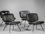 trois fauteuils en cuir noir empilés les uns sur les autres dans une pièce
