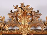 a gold mirror with a bird and flowers on it
