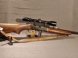 un vieux fusil avec un canon en bois et une lunette de visée, sur fond blanc