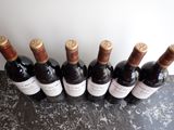 six bottles of wine are lined up on a counter top