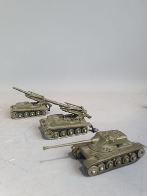 four small toy tanks sitting on a white surface