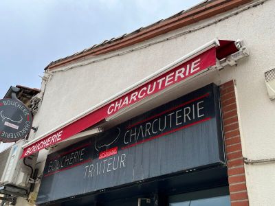 une enseigne sur le mur d'un immeuble où l'on peut lire « charquetrie »
