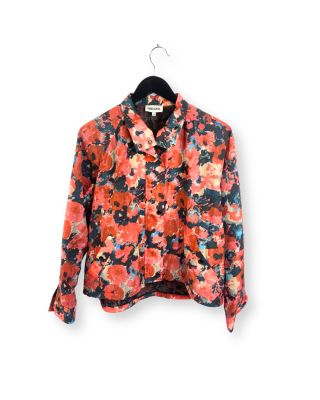 une chemise à motifs floraux orange et noire suspendue à un cintre