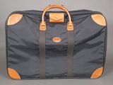 a black suitcase with a brown handle on a gray background