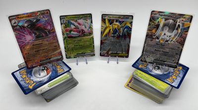 quatre cartes Pokémon différentes posées les unes sur les autres sur une table