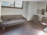 une photo d'un salon avec un canapé et un fauteuil