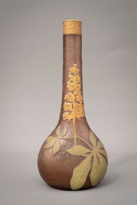 un vase marron orné d'une fleur jaune