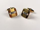 a pair of gold and silver cufflinks on a white background