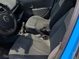 the interior of a blue car with the door open and the driver ' s seat down