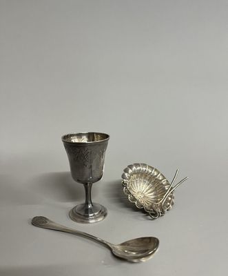 une tasse et une cuillère en argent posées l'une à côté de l'autre sur une table