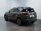 the rear view of a grey suv parked in a room