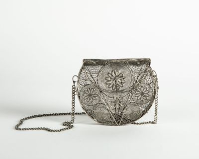 a silver purse with a chain around it on a white background