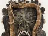 an image of a wooden mask hanging on a wall