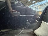 a man standing next to a car with a broken door handle