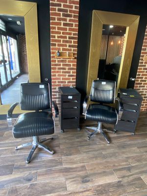 three black chairs in a room with a brick wall