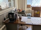 un bureau dans une pièce où s'entassent de nombreux papiers
