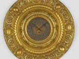 une image représentant une assiette en or avec une horloge au centre