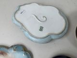 a small blue and white plate sitting on a table next to a bowl