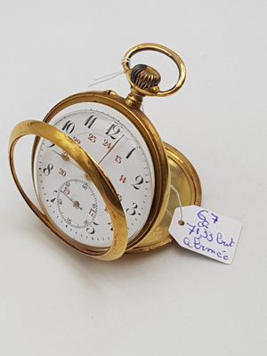 une montre de poche en or sur fond blanc, avec une étiquette de prix