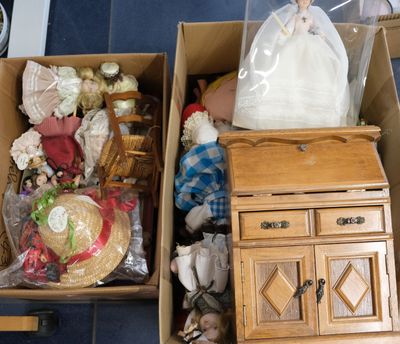 two boxes with dolls in them sitting on the floor