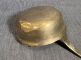 a gold spoon with a handle on a blue cloth
