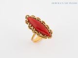 a close up of a ring with a red stone in it