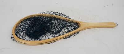 a wooden paddle with a black net on top of it