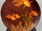 a decorative plate with gold fish on it