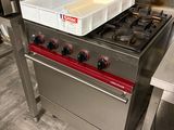 une cuisinière avec une casserole posée dessus, dans une cuisine