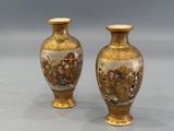 pair of vases on a table with a gray background
