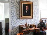 un tableau accroché au mur d'une pièce où se trouvent une table et des chaises