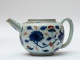 une théière bleue et blanche décorée de fleurs et de feuilles