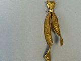 a gold plated brooch with a fish on it