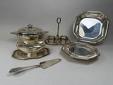 several pieces of silverware are arranged on a white surface