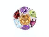 un gros plan d'une bague ornée de pierres multicolores sur fond blanc