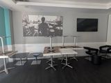 a room with a desk, chairs, and a picture on the wall