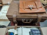 a brown suitcase with a brown leather bag on top of it