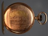 a close up of a gold pocket watch on a table