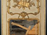 un miroir avec un cadre doré et une croix dessus