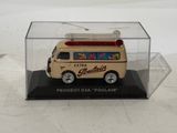 a toy van in a clear case on a white surface