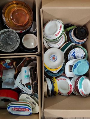 une boîte remplie de tasses et de sauces posée par terre