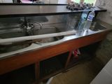 a sink in a kitchen with a lot of clutter on the counter
