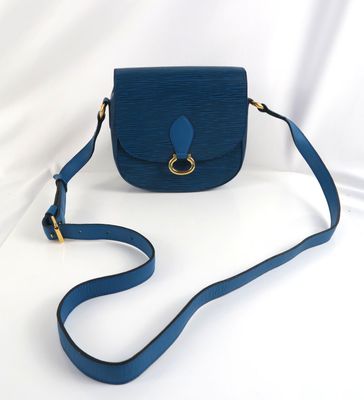 le petit sac à main bleu est posé sur une surface blanche