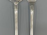 two spoons and a fork on a table with a gray background