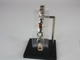 silver bracelet with garnetts and garnetts on a black stand