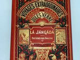 an old book on a white table with a red cover