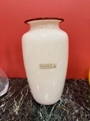 a white vase sitting on a marble table next to a lemon
