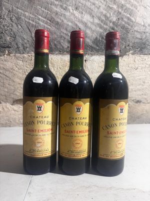trois bouteilles de vin posées sur une table près d'un mur